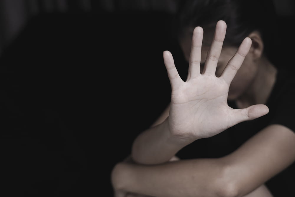 Image is of an individual raising a hand while facing a difficult situation, concept of an Aiken sexual assault lawyer helping clients respond to serious allegations.