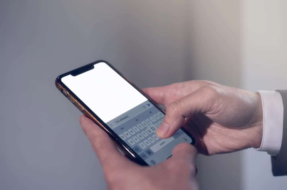 Image is of a person typing a message on a smartphone, concept of an Aiken harassment and stalking lawyer reviewing digital communications as evidence.