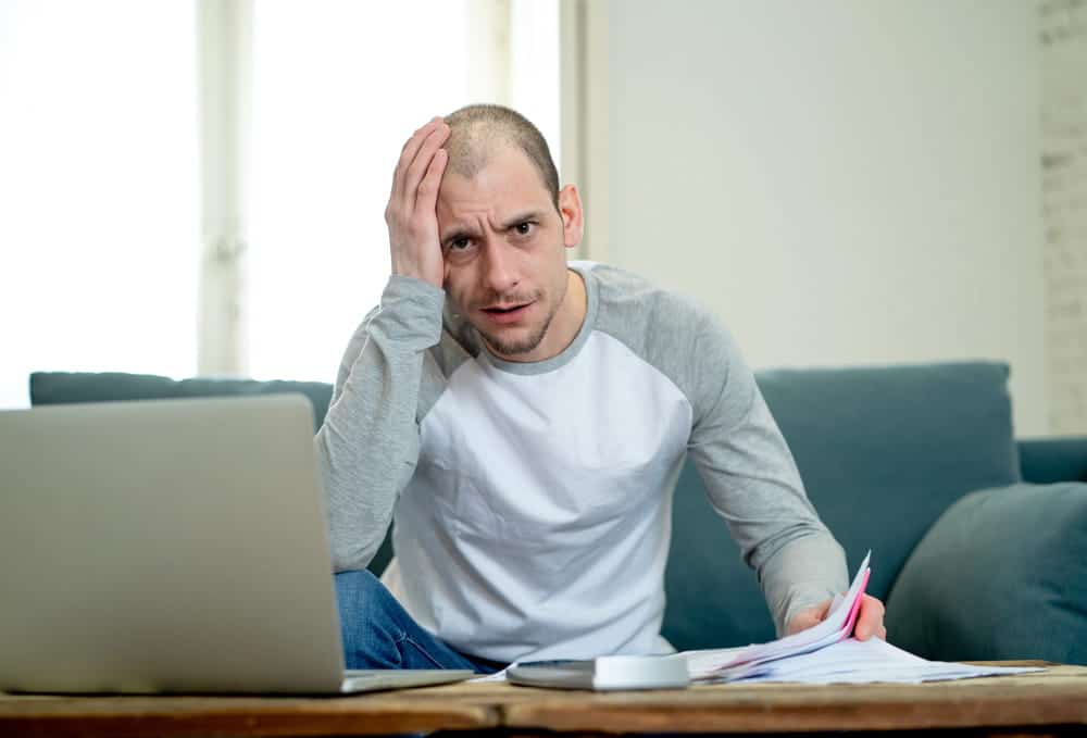 Image is of a person reviewing paperwork and expenses at home, concept of a slip and fall lawyer helping recover financial losses after an injury.