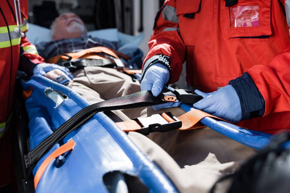 Image is of emergency responders transporting an injured patient by stretcher, concept of an Aiken spinal cord injury lawyer representing victims after serious accidents.