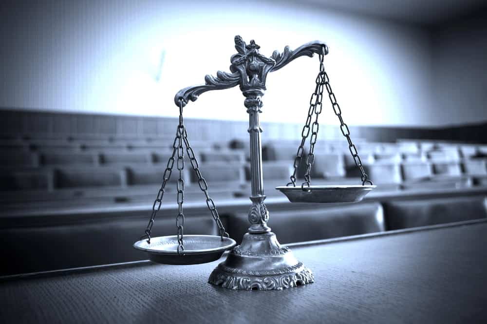 Image is of scales of justice displayed inside a courtroom, concept of an Aiken theft lawyer representing individuals facing theft allegations.