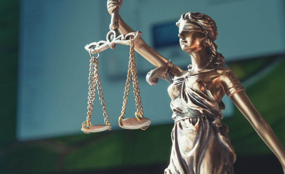 Image is of a Lady Justice statue holding scales of justice, concept of a violent crime lawyer protecting the legal rights of individuals accused of violent offenses.