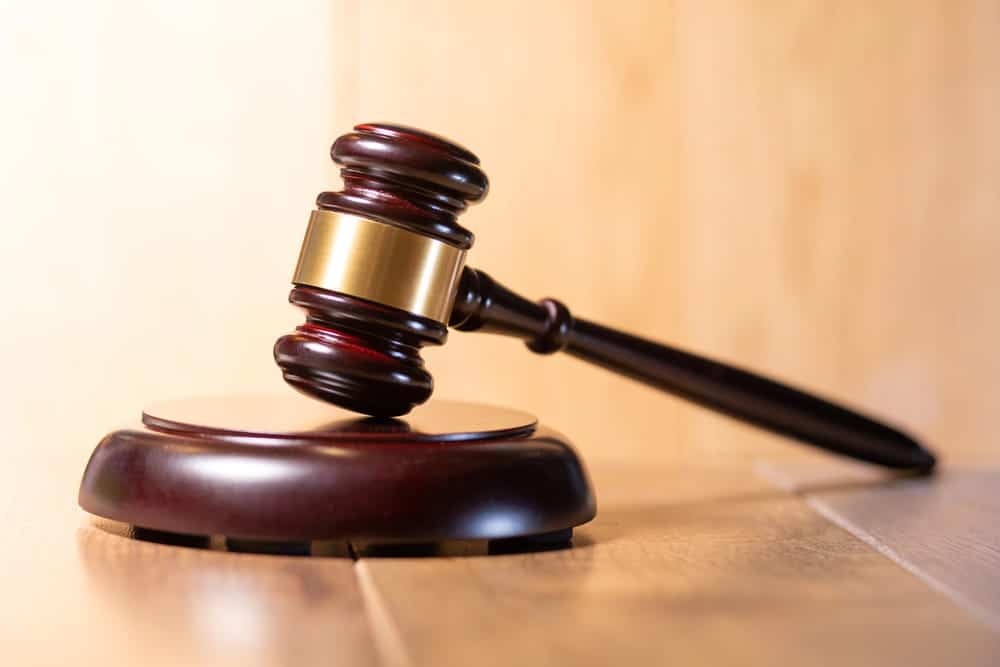 Image is of a judge's gavel resting on a courtroom bench, concept of Aiken white collar crime defense representing individuals accused of financial misconduct.
