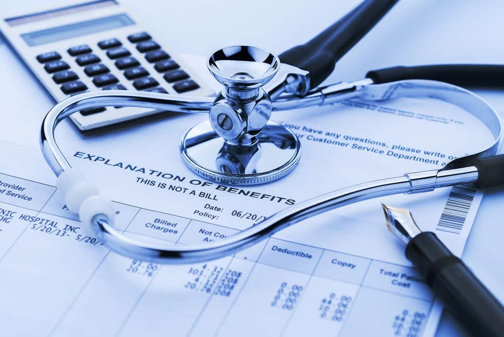 Image is of medical billing documents and a stethoscope, concept of a workers' compensation lawyer helping address treatment costs after a job-related injury.