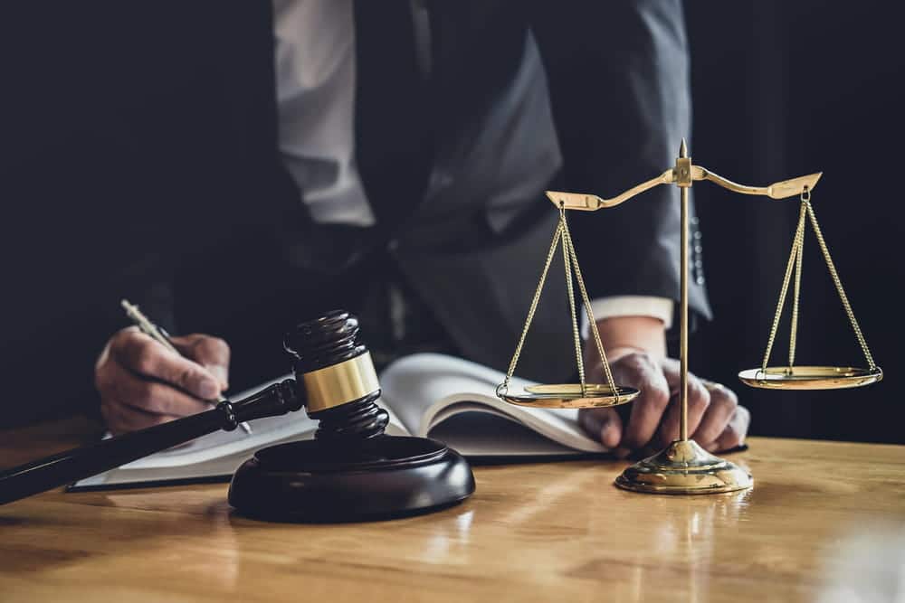 Image is of an attorney reviewing legal documents beside a gavel and scales of justice, concept of a DUI lawyer in Aiken providing DUI defense representation.