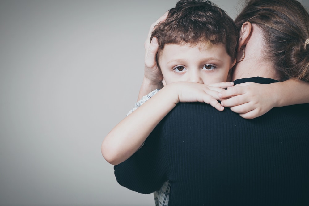 Image is of a child being comforted by a parent, concept of a family law attorney assisting with child custody and parenting matters.