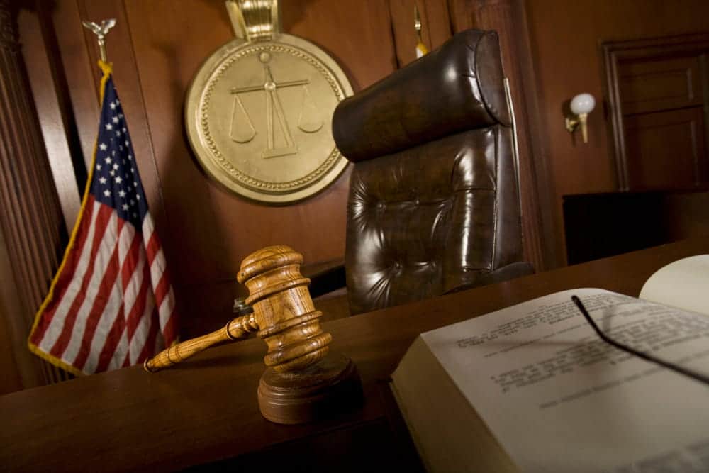 Image is of a courtroom with a judge's gavel and judicial bench, concept of a family law attorney representing clients in family court proceedings.