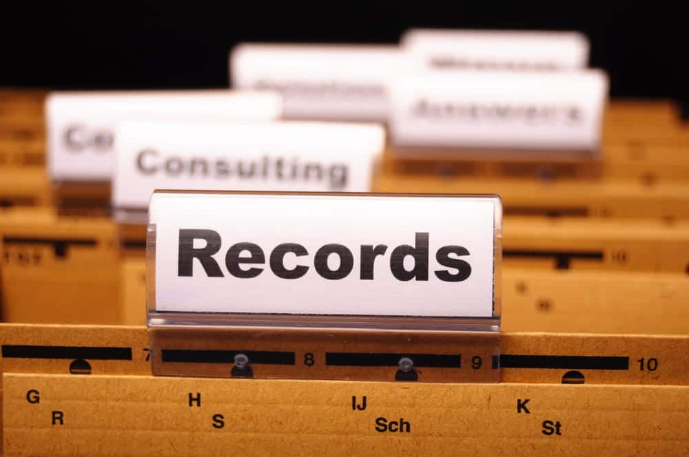 Image is of organized records stored in a filing system, concept of reviewing past offenses and criminal history related to drug charges in Aiken.