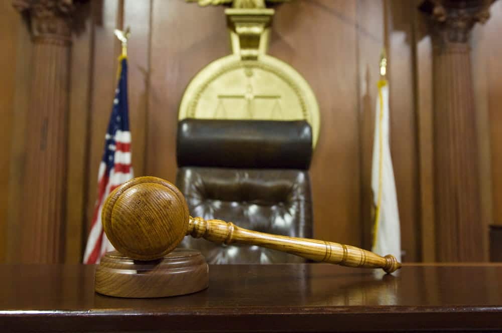 Image is of a courtroom gavel placed before a judge's bench, concept of a DV bond hearing in Aiken.