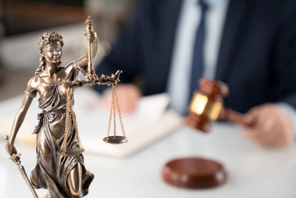 Image is of a Lady Justice statue displayed in a legal office setting, concept of a DV bond hearing in Aiken.