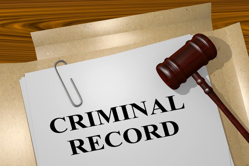 Image is of a criminal record document with a judge's gavel, concept of drug charges and the expungement process.