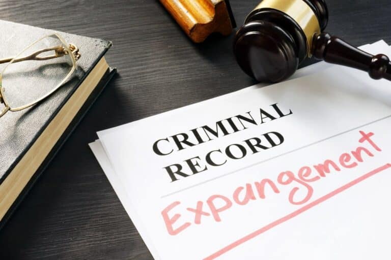 Image is of expungement paperwork labeled with a criminal record, concept of drug charges being removed from a record.