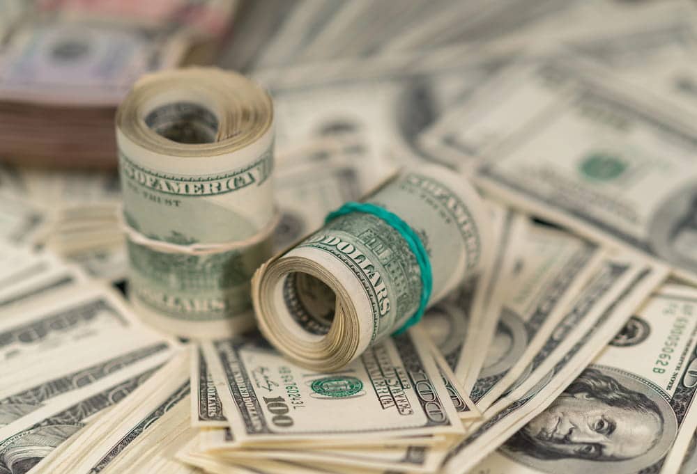 Image is of rolled U.S. currency symbolizing financial compensation and damages that may be recovered after a truck crash in Aiken.