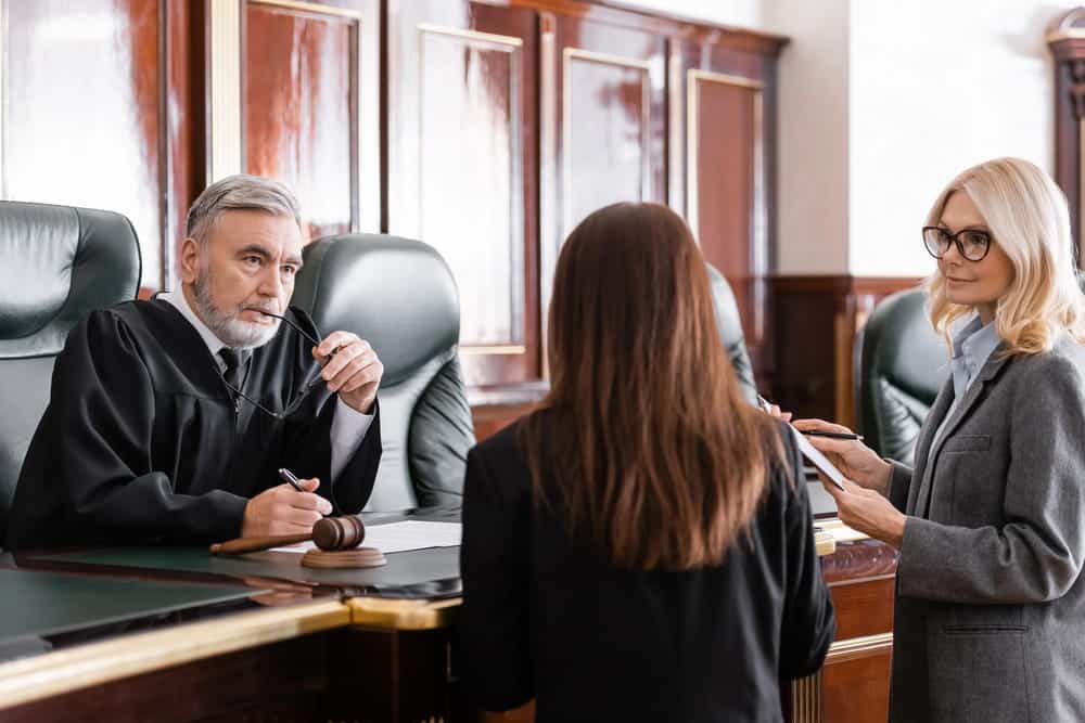 Image is of a judge listening to attorneys during a family court hearing involving child custody.