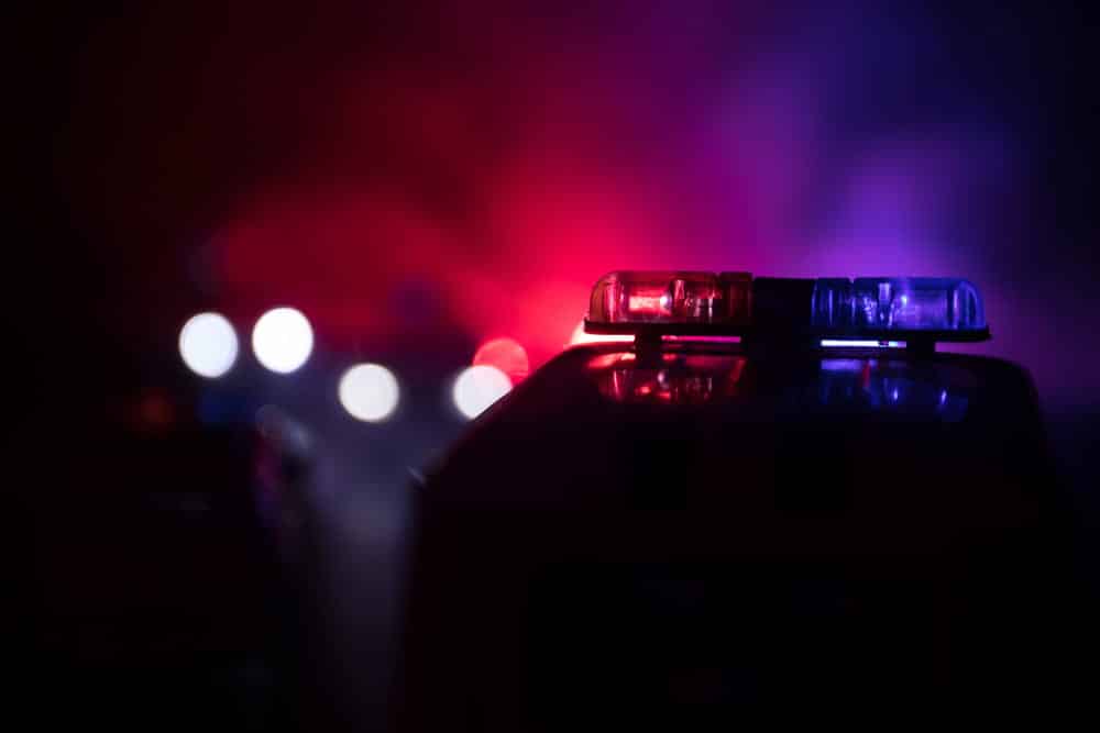 Image is of police emergency lights during a nighttime traffic stop, concept of prior DUIs affecting criminal penalties in Aiken.