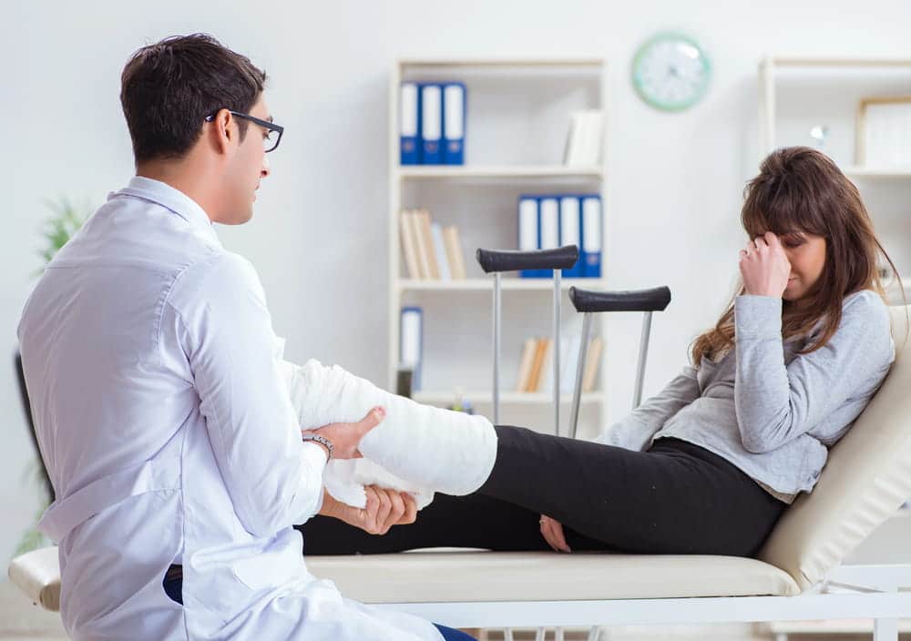 Image is of a patient receiving medical treatment for a leg injury, concept of car accident injuries in Aiken.