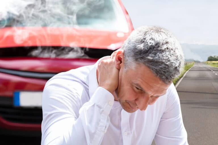 Image is of a person experiencing neck pain after a collision, concept of car accident injuries in Aiken.