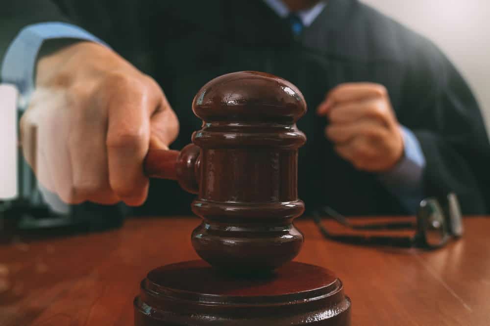 Image is of a judge holding a gavel during court proceedings, concept of drugs in a shared car charges and legal decisions in Aiken.