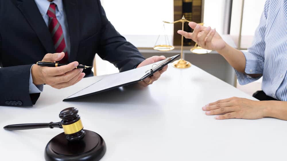 Image is of a lawyer discussing legal documents with a client, concept of obtaining legal guidance after a truck accident in Aiken insurance claim.