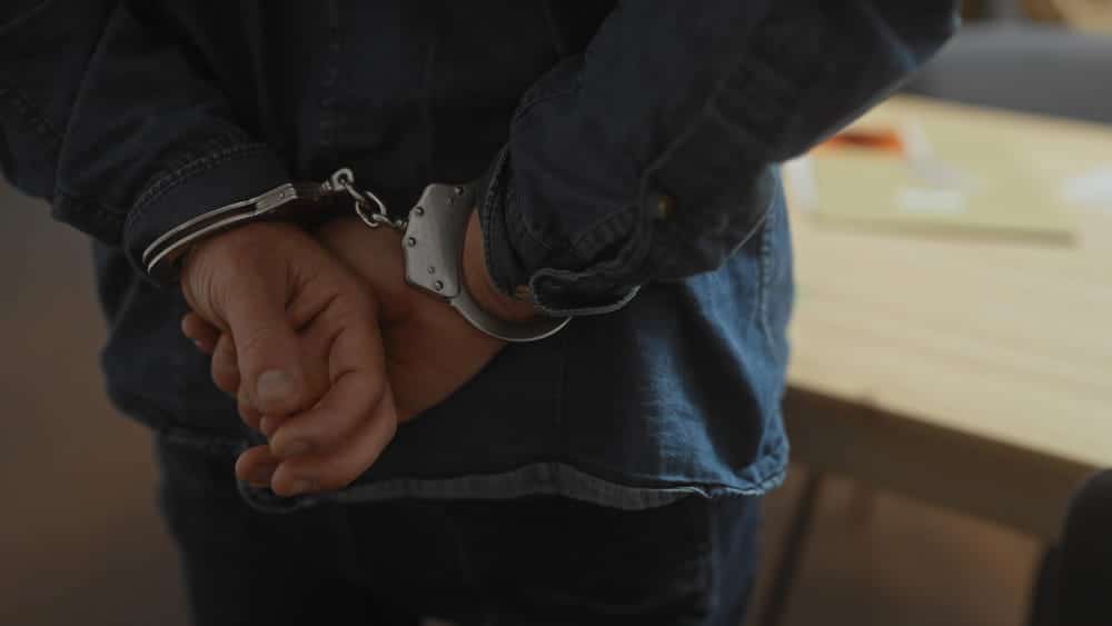 Image is of a person in handcuffs after an arrest, concept of a DV arrest affecting a professional license in Aiken
