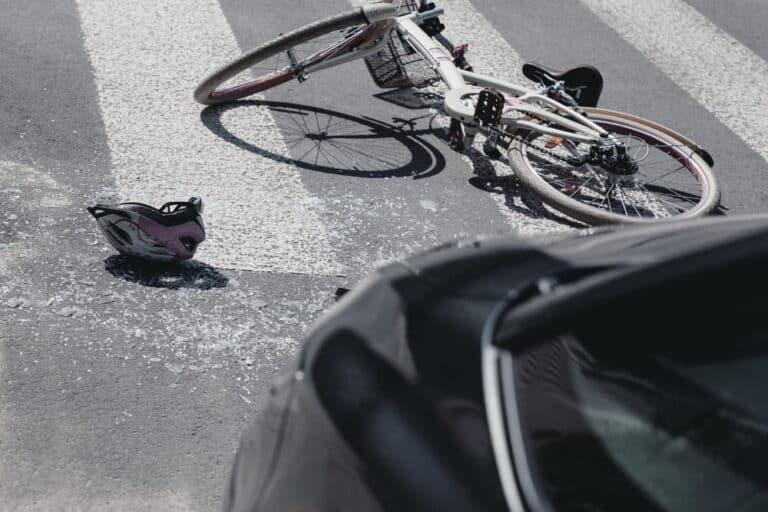 Image is of a bicycle and helmet on the road after a collision with a car, concept of a bike accident case