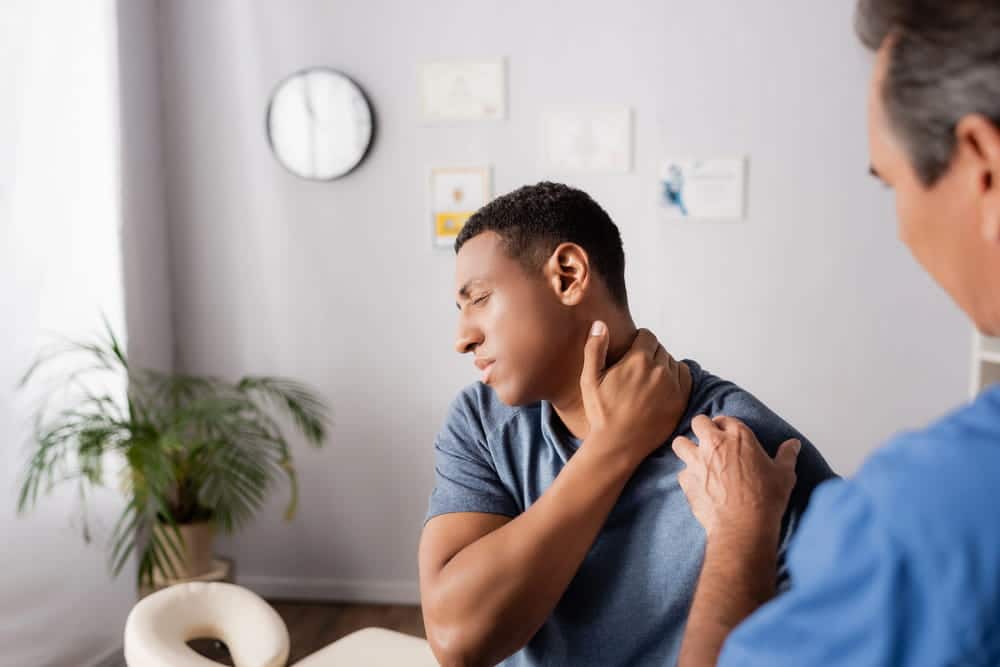 Image is of an injured passenger receiving a medical evaluation after a rideshare accident, showing neck pain following the crash.