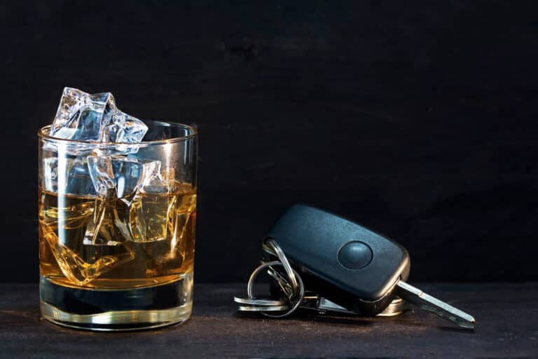 Image is of alcohol beside car keys, concept of how a DUI conviction can affect housing in Aiken.