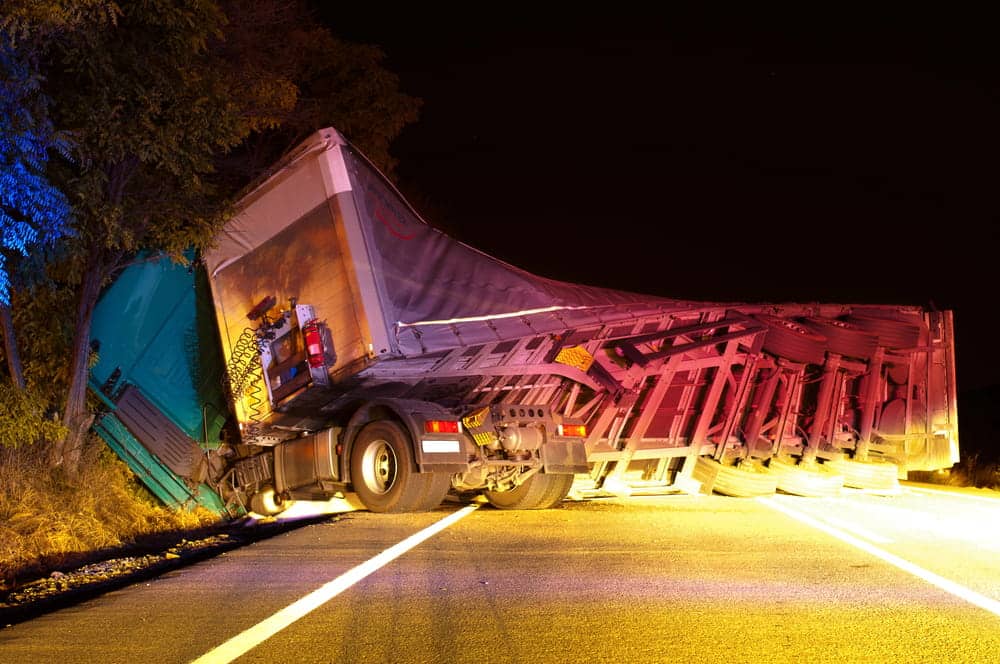 Image is of a jackknifed commercial truck blocking a roadway, concept of a jackknife truck accident in Aiken.