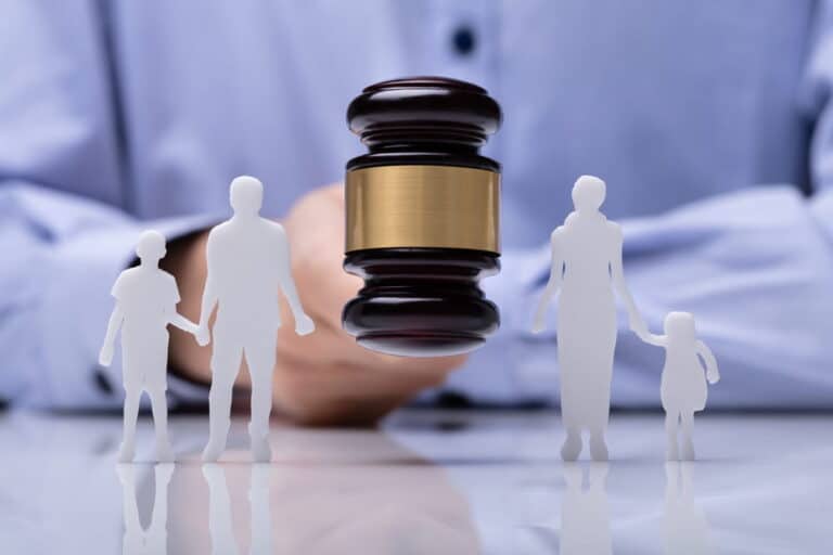 Image is of a judge’s gavel with parent and child figures, concept of a court modifying a child support order.