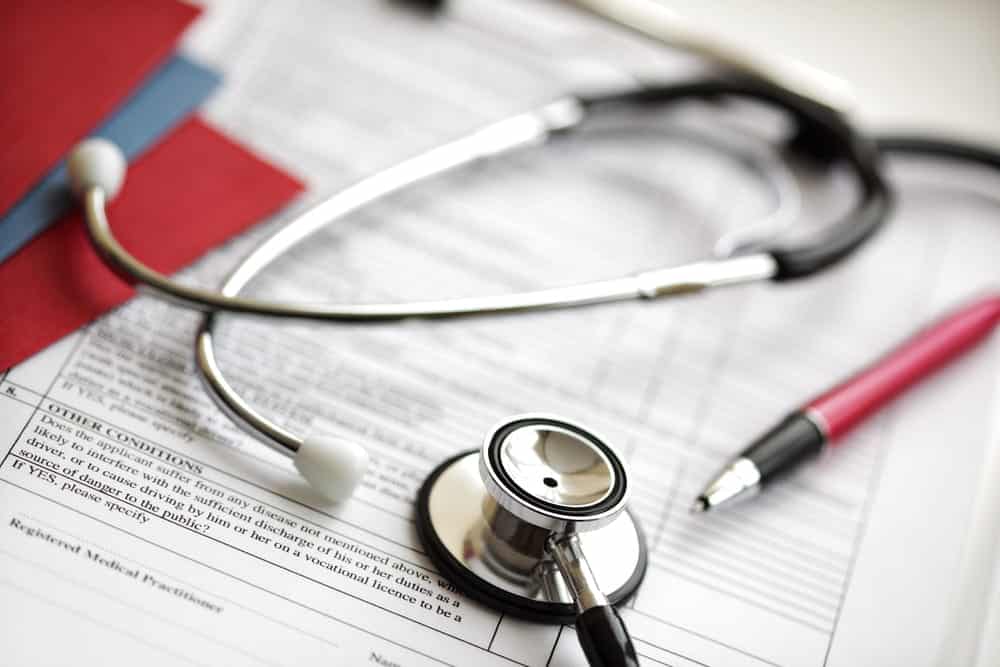 Image is of a stethoscope and medical records, concept of documenting injuries after an accident while biking in Aiken.