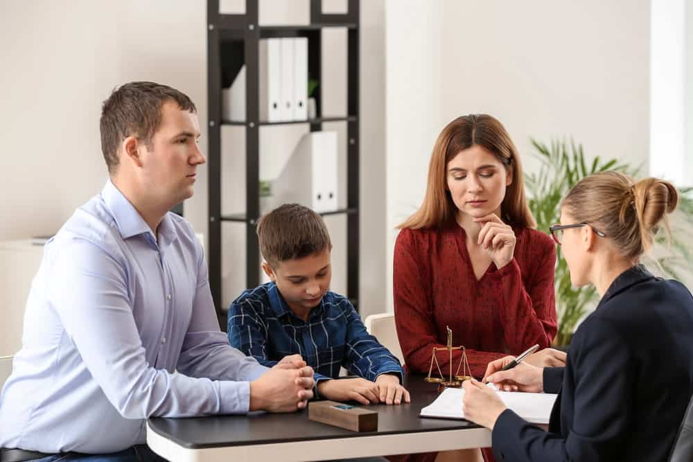 Image is of two parents and their child meeting with a lawyer to discuss legal arrangements related to joint custody in South Carolina.